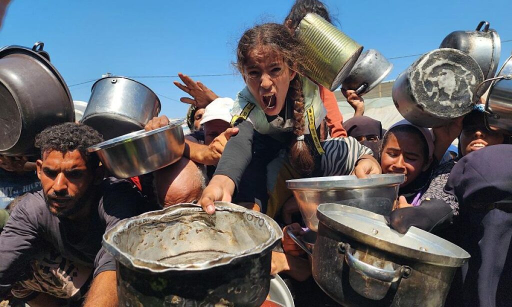 palestinos que luchan contra el hambre se congregan mientras una organizacion benefica distribuye alimentos en la zona de al mawasi de khan yunis gaza