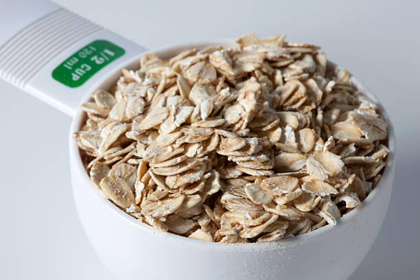 a half a cup of oatmeal in a half cup measuring cup. selective focus.