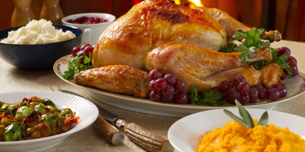 Pavo asado acompañado de puré y guarniciones.
