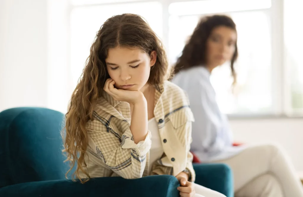 unhappy offended caucasian teenager girl ignores adult mom after quarrel sofa living room scaled